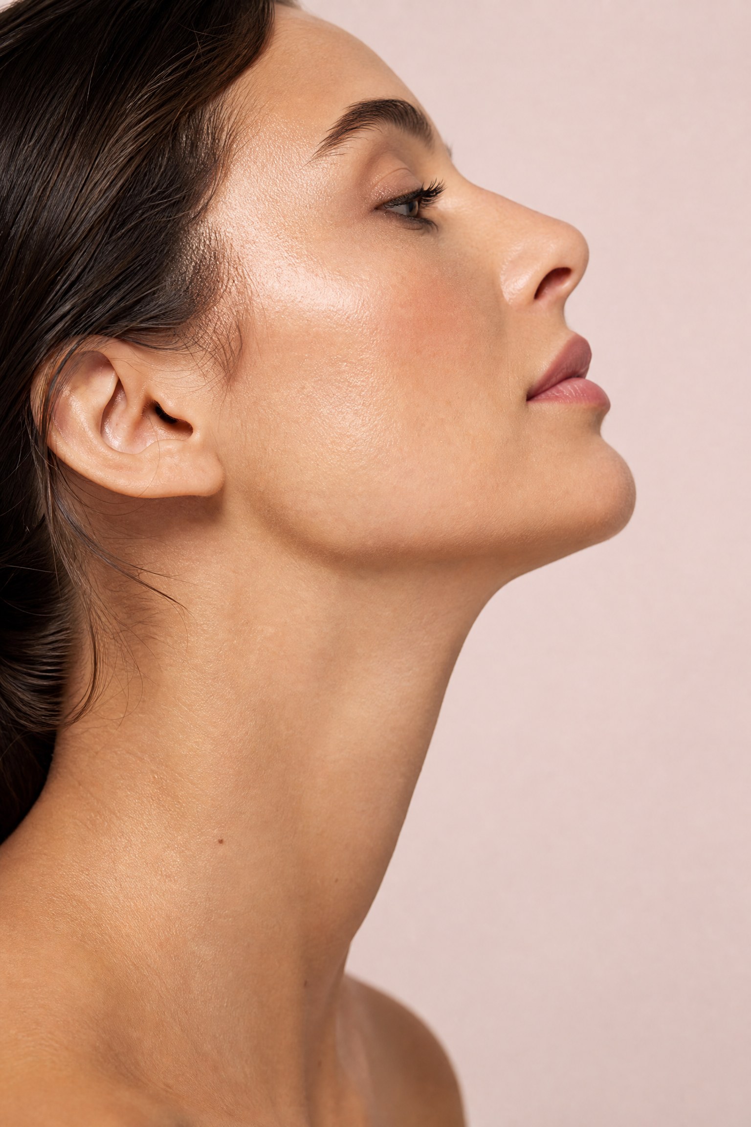 Close-up profile portrait of a woman showing the chin, jawline and under-chin area — the key region affected by a double chin and submental fullness, treated at Facial Sculpting London